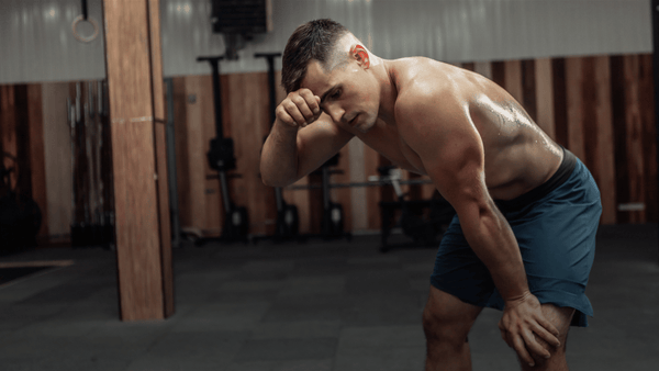 Exhausted athlete recovering between high-intensity training efforts, illustrating heat accumulation and fatigue during repeated performance.