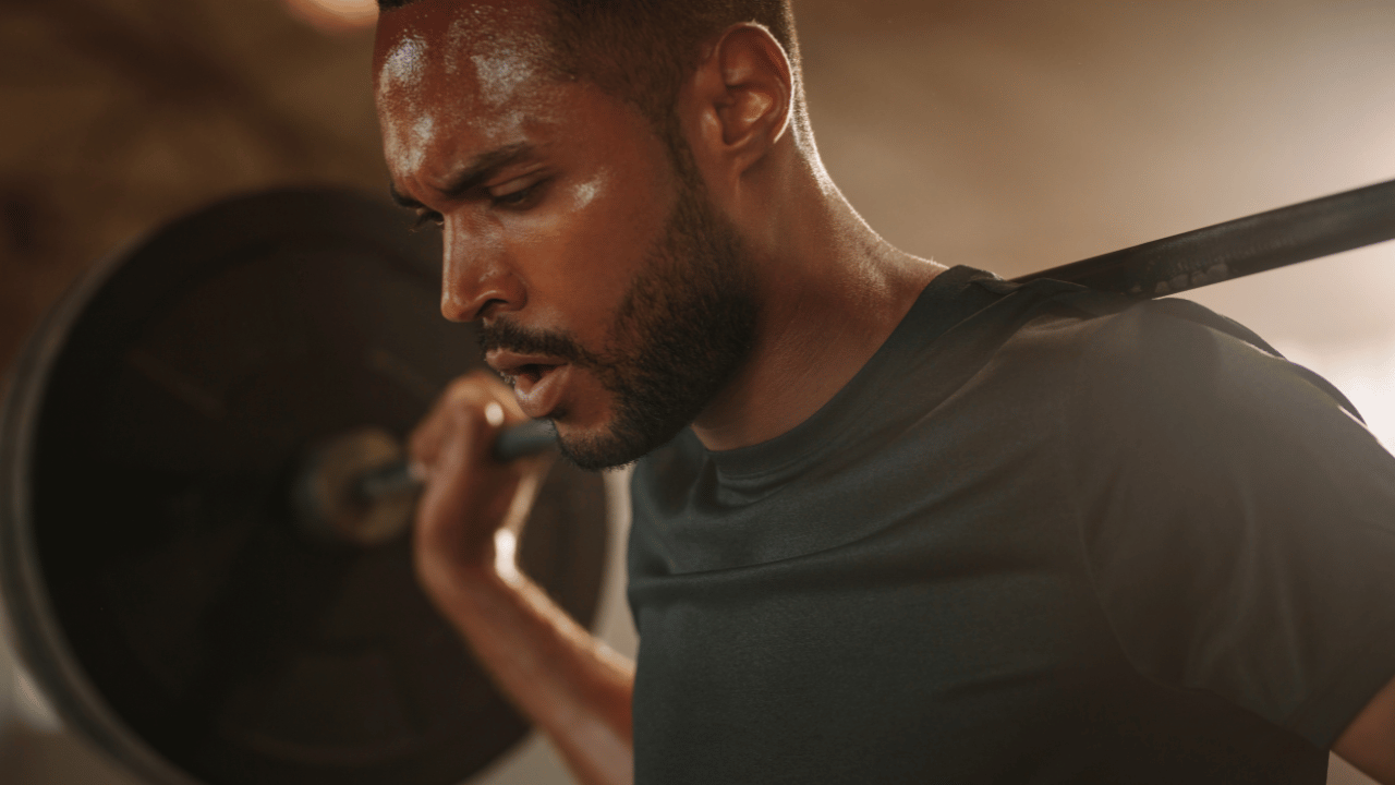 Sweaty athlete performing high-intensity strength training while experiencing heat accumulation and physical fatigue during repeated efforts.
