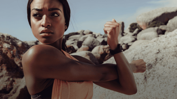 Female athlete stretching outdoors before training, illustrating movement preparation, athletic performance and physical readiness.
