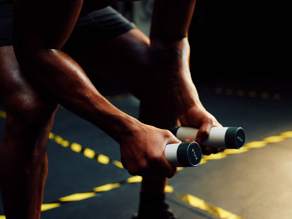 Athlete using KYLA palm cooling devices between sets to manage heat buildup and maintain performance during high-intensity training